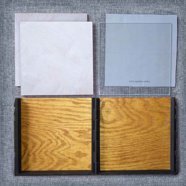 The brown wooden pochade box is open and you can see all part that it contains: Two gesso primed wooden panels, a transparent palette and a neutral gray paper to use under the palette