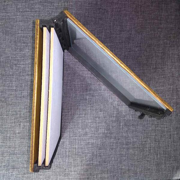 The pochade box is open like a book and you can see that it contains two gesso primed wooden panels as well as a transparent palette and a neutral gray paper under the palete